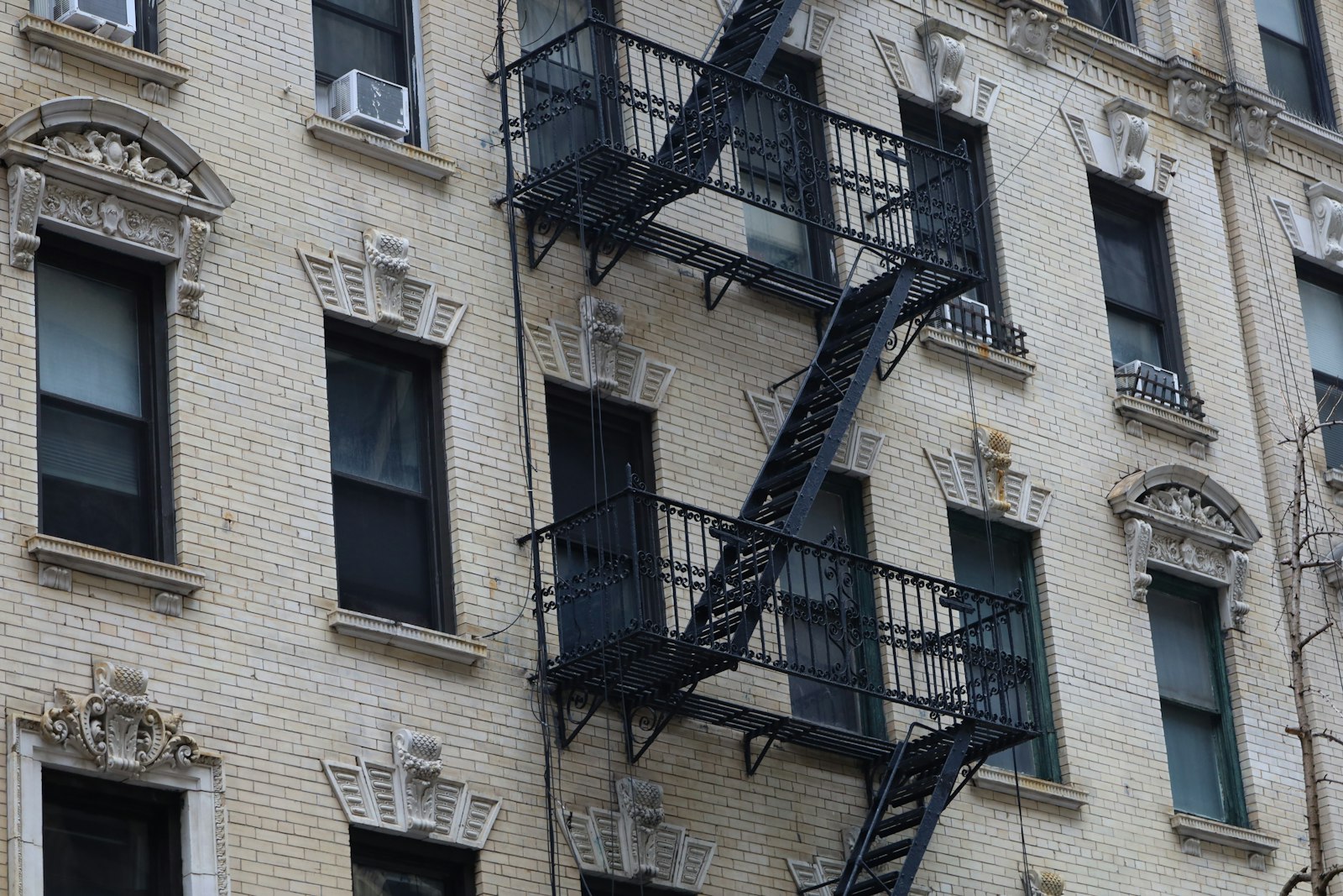 Ornate cornice detail and cast-iron fire escapes on a prewar NYC apartment building